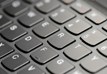 Closeup of computer keyboard keys with narrow focus and selectively blurred background