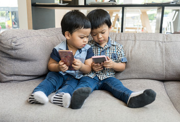 Young Asian boys play on smart phone
