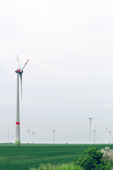 Yard of windmill power generator under blue sky. Eco power. Wind turbines generating electricity....