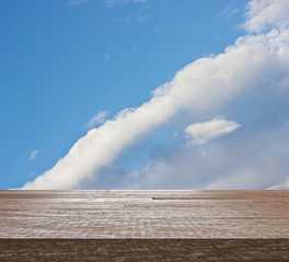 Wooden table top on blue sky with cloud