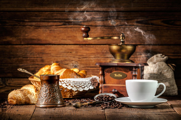 Coffee and croissants on wooden background