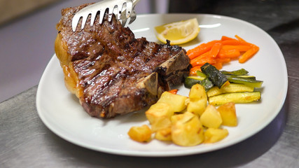 Preparing a dish of meat in a restaurant.