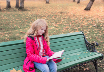 girl with book in autumn park