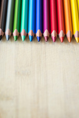 Obraz premium Color Pencils on wood texture. Macro shot of colorful pencils. Vertical view of pencils.