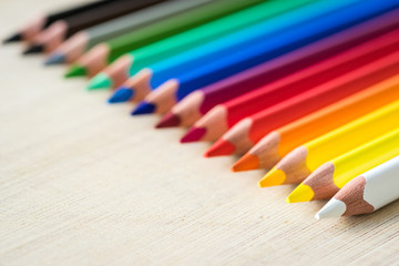 Obraz premium Color Pencils on wood texture. Macro shot of colorful pencils. Horizontal view of pencils. Selective focus.