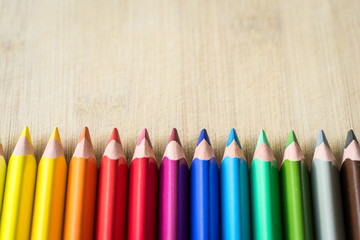 Obraz premium Color Pencils on wood texture. Macro shot of colorful pencils. Horizontal view of pencils.