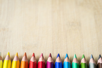 Obraz premium Color Pencils on wood texture. Macro shot of colorful pencils. Horizontal view of pencils.