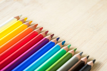 Color Pencils on wood texture. Macro shot of colorful pencils. Horizontal view of pencils.