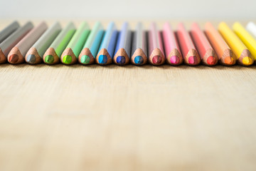 Obraz premium Color Pencils on wood texture. Macro shot of colorful pencils. Horizontal view of pencils. Selective focus.