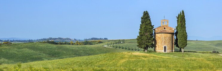panorama with lonely chapel and cypress trees  in Tuscany in Italy