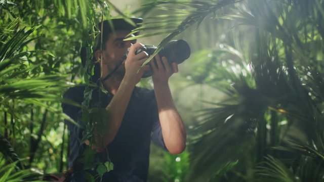Professional Wildlife Photographer Taking Pictures in Jungle Forest. Shot on RED Cinema Camera.