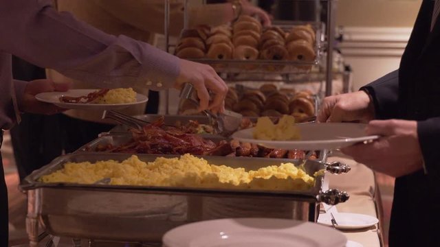 People selecting breakfast food at a conference