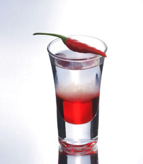 Colorful layered shot with reflection. Alcohol red shooter with chili pepper