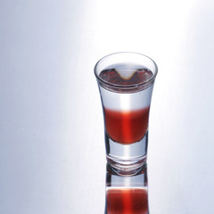 Colorful layered shot isolated on white gray gradient background with reflection. Alcohol shooter