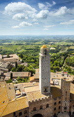 Fototapeta na wymiar tower and chapel in old city under clouds in Tuscany in Italy