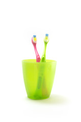 kid toothbrushes in plastic glass isolated on white

