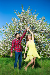 Fototapeta premium young beautiful couple in love dancing in blooming garden