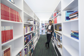 student with tablet in library