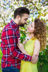 Fototapeta premium young man embracing happy girlfriend in garden