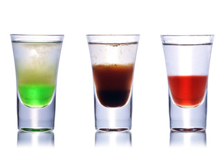 Set of colorful alcoholic cocktails in shot glasses isolated on white with reflection. Colletion of shooters