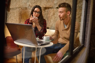 twenty something young couple working with your laptop through the window