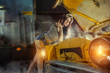 Woman mechanic in sexy shirts is repairing an old car with the w