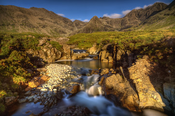 Fairy Pools waterfalls with Sgurr an Fheadain and Cuillin Mountains in sunset light, Isle of Skye, Scotland
