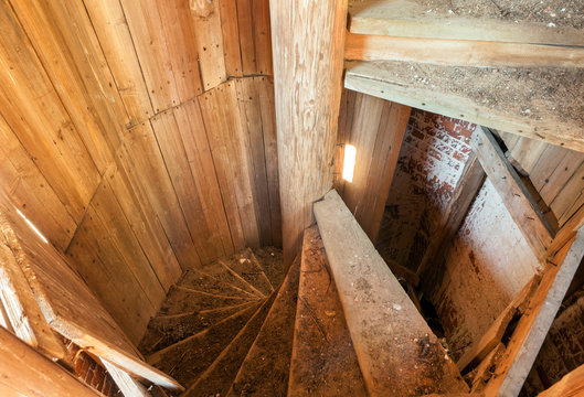 Old spiral staircase made of wood in an abandoned belfry