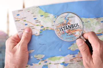 Man consulting a map of Istanbul with a magnifying glass