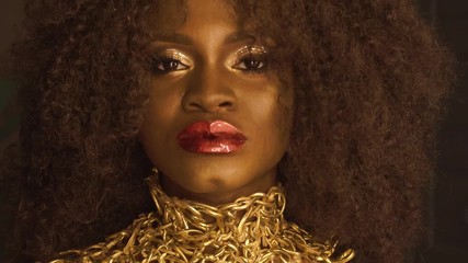 Magic surreal golden african american female model with bright glitter makeup, glossy golden hairstyle and big red lips - Powered by Adobe