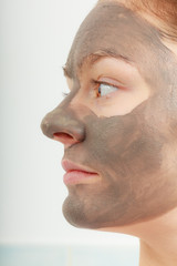 Closeup female face with clay mud facial mask