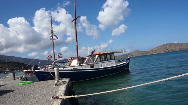 Small ship in the harbor, view of Crete, sea. Camera is on the ship deck.