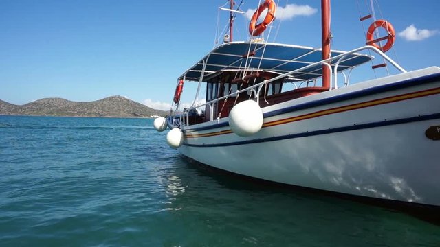 Small ship in the harbor, view of Crete, sea.