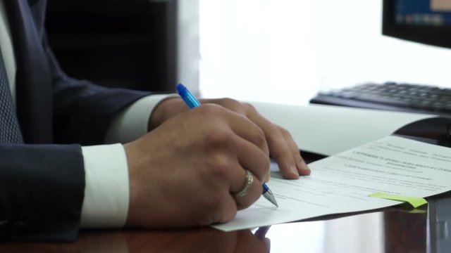 businessman sitting in an office signing a contract