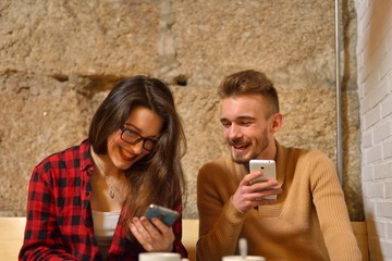 twenty something young couple sharing content with their smartphones
