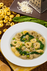 Tortellini Soup with Peas and Spinach. Selective focus.
