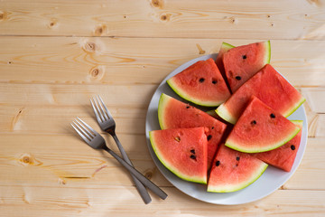 Slices of watermelon on a plate with two forks