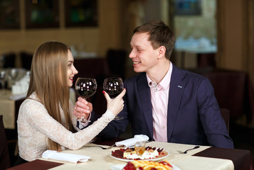 Couple toasting wineglasses in a luxury restaurant.