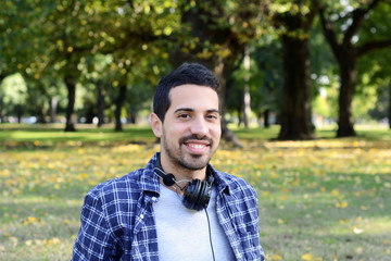 Young man with headphones in a park.