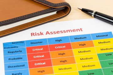 Risk management matrix chart with pen and organizer book; docume