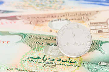 United Arub Emirates dirham coin stand on banknote money