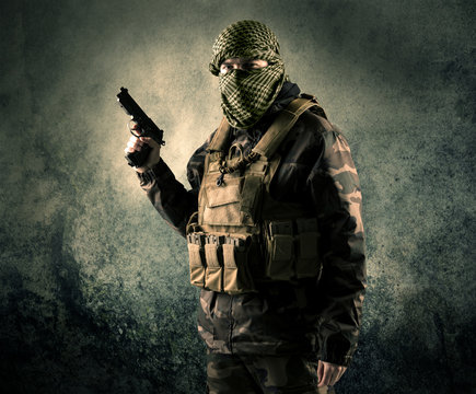 Portrait of a heavily armed masked soldier with grungy backgroun