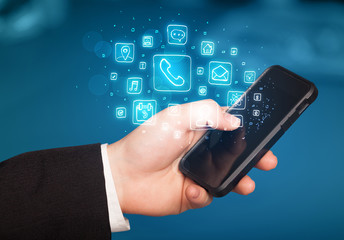 Hand holding smartphone with mobile app icons