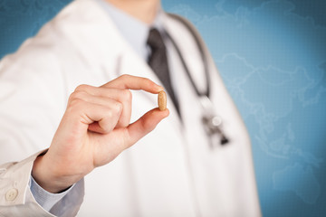 Doctor in white holding a pill