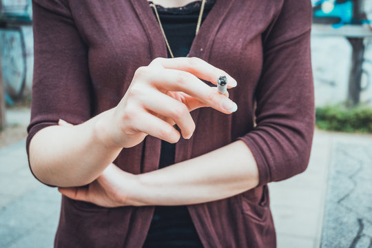 Young female smoker holding a burning cigarette