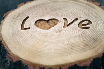Woodcarving. Inscription Love. heart symbol. Background for your