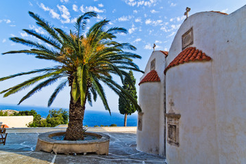 Fototapeta na wymiar Church buildings, palm and cypress trees inside Preveli monastery, island of Crete, Greece