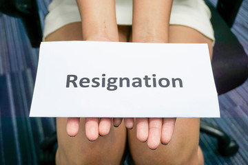 close up woman hands hold a piece of paper of resignation