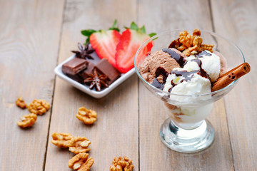 Ice cream sundae, chocolate, walnuts and sliced strawberry 