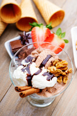 Ice cream sundae, chocolate, walnuts and sliced strawberry 